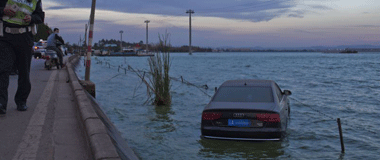 昆明一男子开车时接电话 将车开进滇池