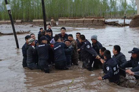 新疆暴雨引发洪水 警察水中拉绳救人