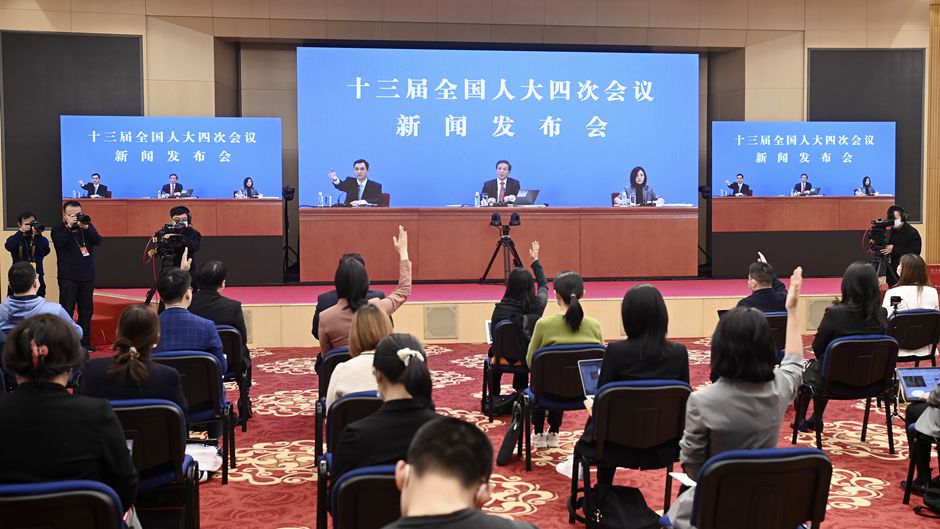 记者在分会场的屏幕前举手提问