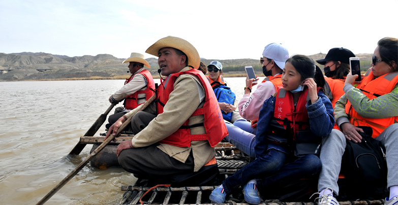 导游带着游客在沙坡头快乐的游玩