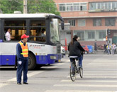 一位女士在协管员和交警的目送下违章过线