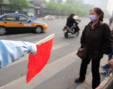 几位行人在协管员的指引下等待过马路