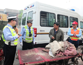 交警在处罚一辆违章穿行的三轮车