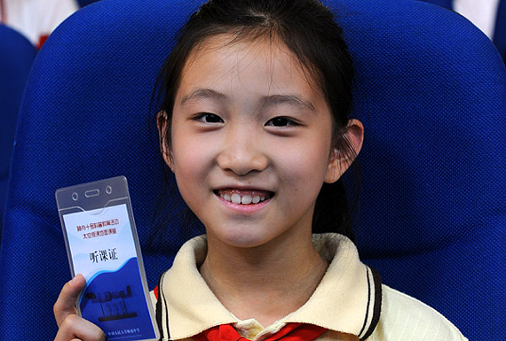 一位学生在展示自己的太空授课听课证