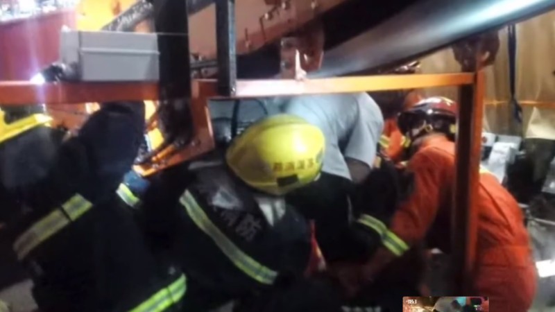 救援现场暖心一幕：消防员用背部为被困者挡住飞溅火花