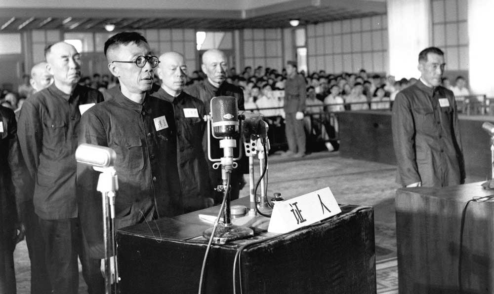 图为前伪满洲国皇帝溥仪在法庭上证明被告人武部六藏和古海忠之操纵伪满洲国，统治和奴役我东北人民的罪行。