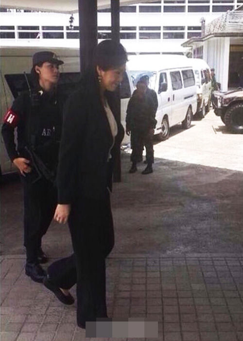 英拉被女军人持枪押送