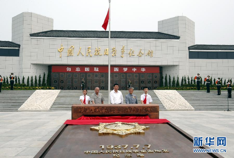 这是习近平和抗战老战士以及少年儿童一起按下启动按钮，为&ldquo;独立自由勋章&rdquo;雕塑揭幕。新华社记者 鞠鹏 摄