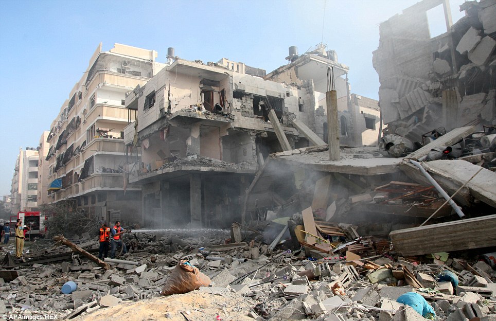 加沙当地的民众在以色列空袭过的一幢建筑里寻找伤员