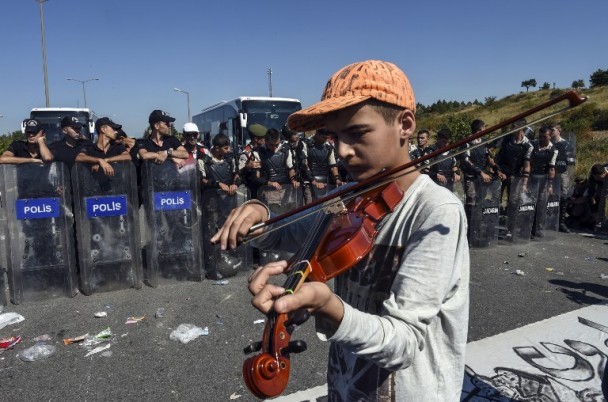 小难民:13岁男孩在警察盾牌阵前拉小提琴