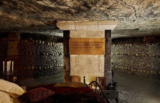 入住这里后，两名客人必须在人类遗骸和头骨迷宫中参观、聆听小提琴演奏以及睡前故事，说书人将会讲述一些有关地下墓穴的传说。图为床脚边贴有标语的柱子。[!--empirenews.page--]