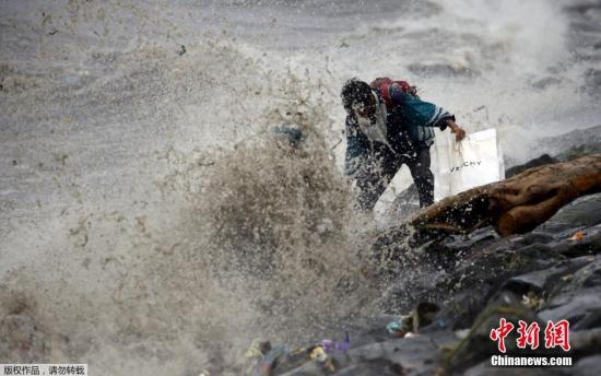 当地时间10月18日凌晨，台风“巨爵”挟带强风登陆菲律宾吕宋岛北部卡西古兰(Casiguran)，沿岸数千居民已经疏散。据菲律宾气象局警告称，台风“巨爵”行进速度减缓，威力可能持续3天。图为菲律宾民众在马尼拉湾内捡拾垃圾。