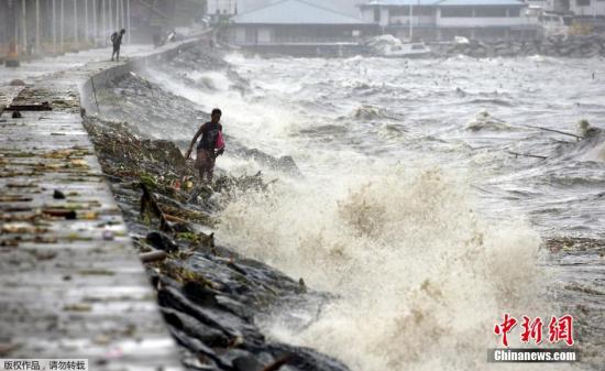 据菲律宾气象局警告称，台风“巨爵”行进速度减缓，威力可能持续3天。图为菲律宾民众在马尼拉湾内捡拾垃圾。