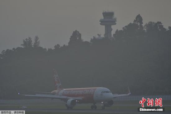当地时间10月9日，一架亚航客机停泊在雾霾笼罩的普吉国际机场。