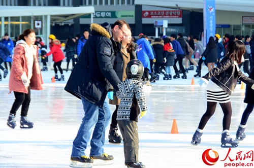 小朋友拉着爸爸的手一起滑冰（拍摄：夏雪）