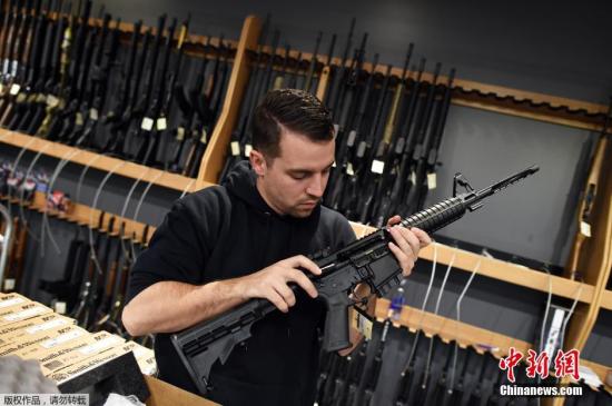当地时间2015年12月9日,美国新泽西州Randolph,民众在RTSP射击馆买枪,练习射击。加州枪击案后,奥巴马采取更为严厉的枪支管制措施,但部分民众依旧选择了依赖枪支以求防身。图为工作人员在展示出售的枪支。