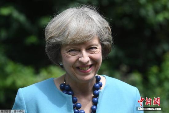 當地時間2016年7月14日，英國倫敦，英國首相特蕾莎·梅在府邸花園中舉辦警察勇敢獎招待會。當日，“時尚女教主”梅姨選擇了藍色係套裝，配上曾出鏡過的藍色項鍊。