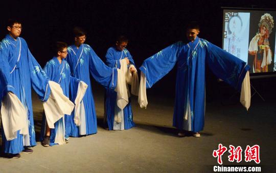 西班牙华裔青少年营员在福州闽剧院青年演员杨帅指导下，模仿闽剧小生表演动作。　刘可耕　摄