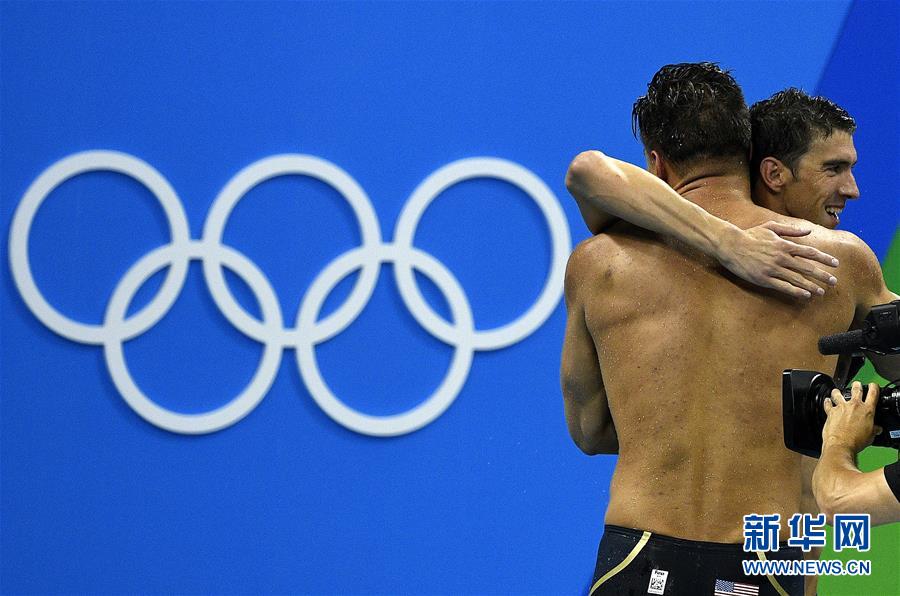 8月7日，美国队选手菲尔普斯（右）赛后与队友拥抱庆祝夺冠。