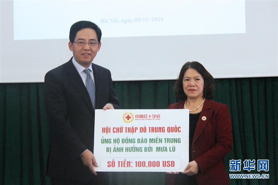 11月8日，在越南首都河内，中国驻越南大使洪小勇（左）代表中国红十字会向越南红十字会主席阮氏春秋提供10万美元紧急救灾援助。