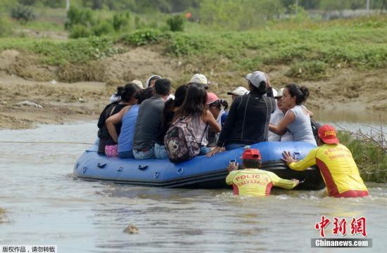 当地时间2017年3月31日，秘鲁北部Piura，当地民众在洪水中转移。近日，南美国家秘鲁遭遇了由暴雨引发的洪水和泥石流灾害。目前已造成至少98人死亡，近百万人受灾。