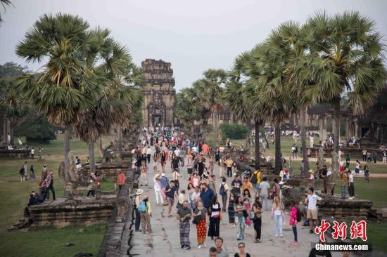 资料图：上千名各国游客守候在柬埔寨暹粒景点&mdash;&mdash;吴哥窟，守候观看日出。 <a target='_blank' href='http://www.chinanews.com/'><p  align=