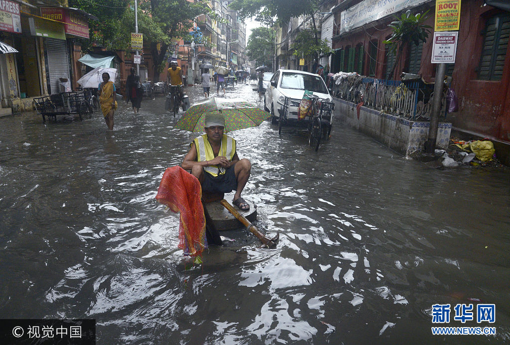 当地时间2017年7月24日，印度加尔各答，加尔各答在一晚上突降83毫米的暴雨，导致市区内出现内涝，民众生活受阻。***_***KOLKATA, WEST BENGAL, INDIA - 2017/07/24: Kolkata Metropolitan Corporation worker sits on open sewer pit to check the water pumping out at waterlogged street on July 24, 2017 in Kolkata. Overnight rain disrupted city life and causing flood like situation in several district of West Bengal resulting. Kolkata received 83 m.m. of rain in Monday morning. (Photo by Saikat Paul/Pacific Press/LightRocket via Getty Images)