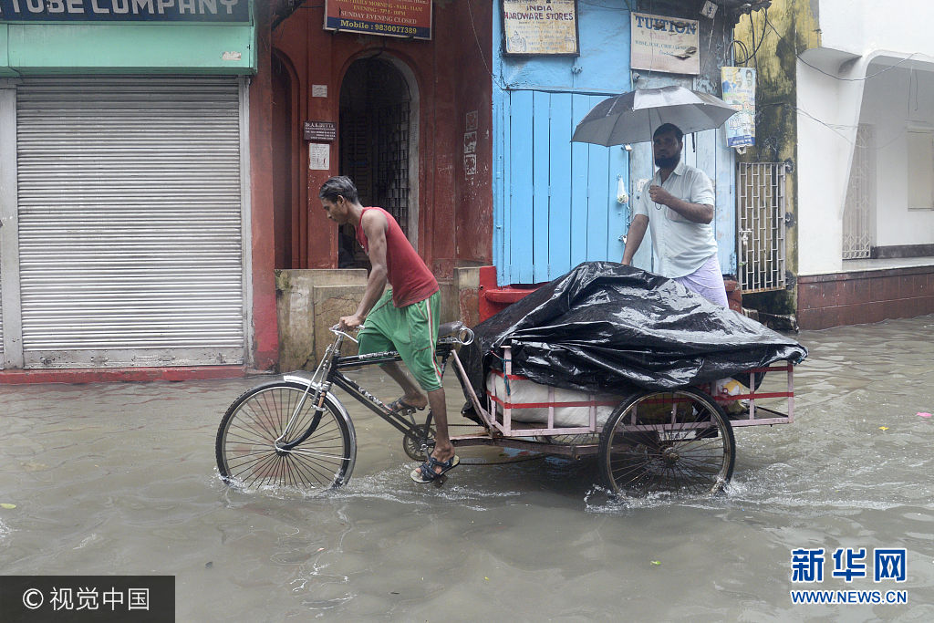 当地时间2017年7月24日，印度加尔各答，加尔各答在一晚上突降83毫米的暴雨，导致市区内出现内涝，民众生活受阻。***_***KOLKATA, WEST BENGAL, INDIA - 2017/07/24: Cycle van laborer wades through the waterlogged street on July 24, 2017 in Kolkata. Overnight rain disrupted city life and causing flood like situation in several district of West Bengal resulting. Kolkata received 83 m.m. of rain in Monday morning. (Photo by Saikat Paul/Pacific Press/LightRocket via Getty Images)