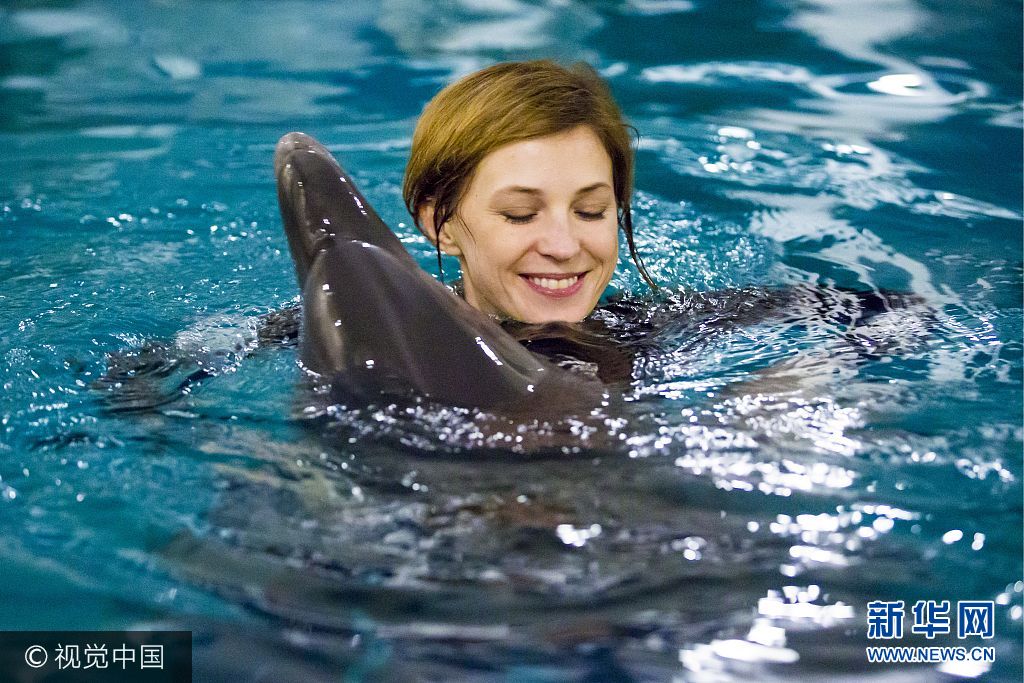当地时间2016年3月15日，克里米亚辛菲罗波尔，克里米亚美女检察长娜塔莉亚&middot;波克隆斯卡娅在水族馆中与海豚玩耍。***_***SIMFEROPOL, RUSSIA. MARCH 15, 2016. Natalia Poklonskaya, prosecutor general of the Republic of Crimea, swimming with a dolphin at the Akvatoria dolphinarium. Ruslan Shamukov/TASS