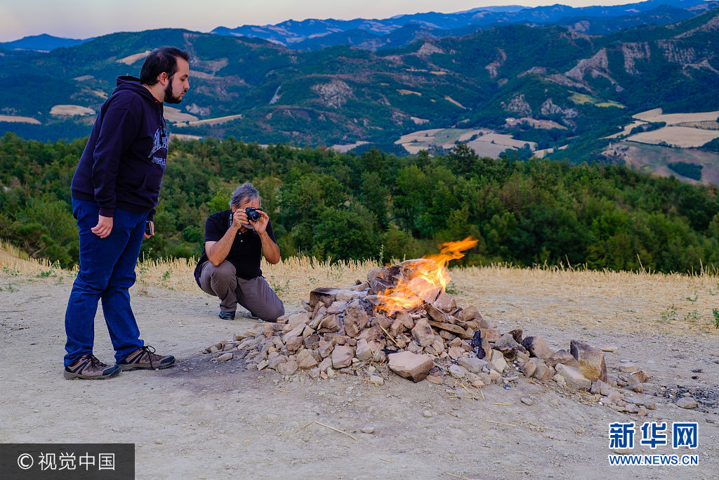 当地时间2017年8月14日，意大利弗利，游客们在看着Monte Busca 火山。Monte Busca 火山是意大利最小的火山，由于烃类气体与氧气接触燃烧，产生了火焰。这这现象也被称为&ldquo;火焰喷泉&rdquo;。***_***FORLI, ITALY - AUGUST 14: Tourists look the volcano's flame coming out from the subsoil on August 14, 2017 in Forli, Italy. The volcano of Monte Busca is the smallest in Italy and is in the Province of Forli near Tredozio village. The flames are due to the release of hydrocarbon gases which in contact with oxygen creates a flame. The phenomenon is also known as 'flaming fountain'. (Photo by Massimiliano Donati/Awakening/Getty Images)