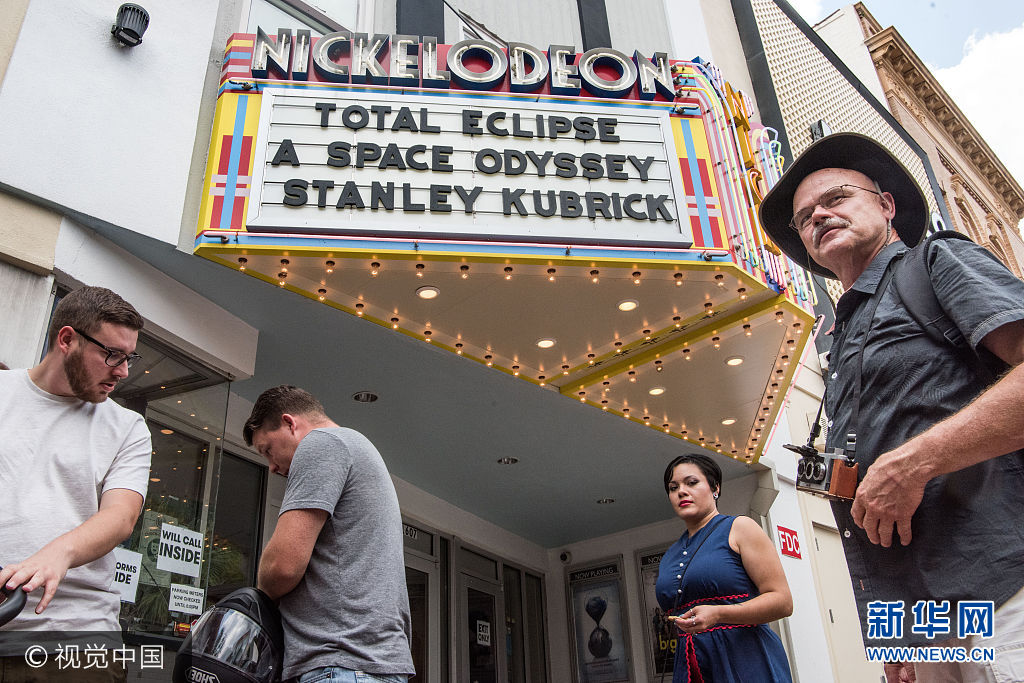 當地時間2017年8月20日，美國南卡羅萊納州哥倫比亞，民眾舉行活動準備觀賞日食奇觀。***_***COLUMBIA, SC - AUGUST 20: People walk by the Nickelodeon Theater August 20, 2017 in Columbia, South Carolina. COLUMBIA, SC - AUGUST 20: Sophia Neghesti sells eclipse glasses on Main St. August 20, 2017 in Columbia, South Carolina. The state capital city is one of the prime destinations for viewing Monday's solar eclipse and NASA expects clear weather could bring over a million visitors to the state. (Photo by Sean Rayford/Getty Images)