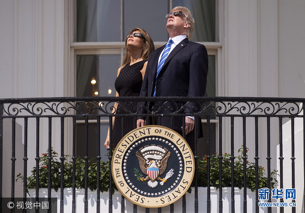 當地時間2017年8月21日,美國華盛頓,美國總統特朗普、“第一夫人”梅拉尼婭、“第一千金”伊萬卡、司法部長塞申斯及商務部長威爾伯·羅斯等人在白宮陽臺上觀看日全食。 此次日食始于東北太平洋,橫跨美國,至大西洋中部結束。當地時間21日上午9時5分(北京時間22日0時5分),美國西海岸民眾開始看到月亮逐漸遮蔽太陽;美國東部時間下午4時9分(北京時間22日4時9分),美國東海岸民眾可見的最後月亮陰影消失,美國本土可見的日食現象結束。此次日食在地球表面形成了113公裏寬的日全食帶,斜跨美國14個州。西起俄勒岡州林肯市、東至南卡羅來納州查爾斯頓的日全食帶地區生活的1220萬美國人,以及來自世界各地的天文愛好者都經歷了兩分鐘左右的完全黑暗。***_***President Donald Trump and First Lady Melania trump wear special solar glasses as they view the total solar eclipse from the White House in Washington, D.C. on August 21, 2017. Photo by Kevin Dietsch/UPI Photo via Newscom