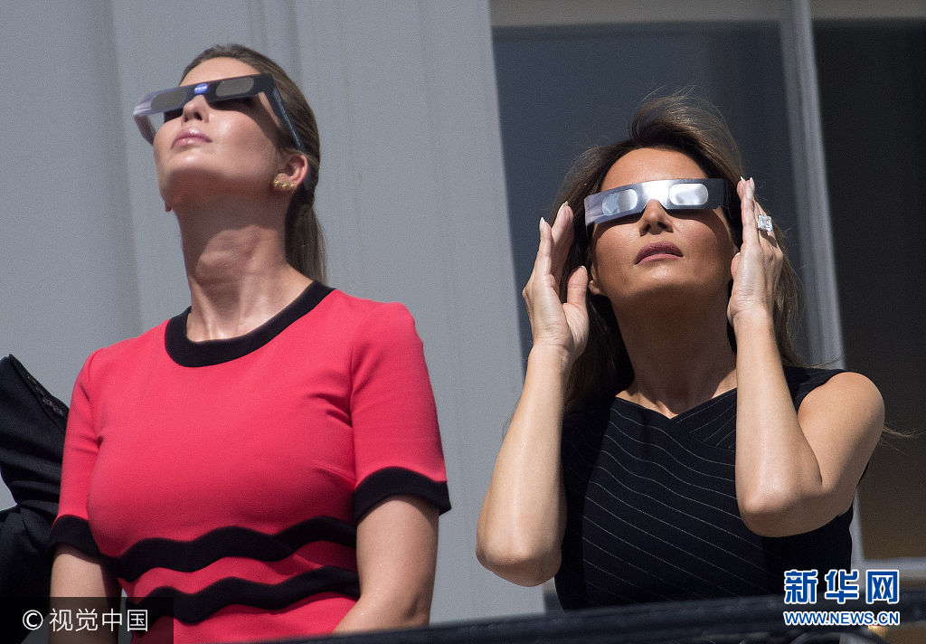 當地時間2017年8月21日,美國華盛頓,美國總統特朗普、“第一夫人”梅拉尼婭、“第一千金”伊萬卡、司法部長塞申斯及商務部長威爾伯·羅斯等人在白宮陽臺上觀看日全食。 此次日食始于東北太平洋,橫跨美國,至大西洋中部結束。當地時間21日上午9時5分(北京時間22日0時5分),美國西海岸民眾開始看到月亮逐漸遮蔽太陽;美國東部時間下午4時9分(北京時間22日4時9分),美國東海岸民眾可見的最後月亮陰影消失,美國本土可見的日食現象結束。此次日食在地球表面形成了113公裏寬的日全食帶,斜跨美國14個州。西起俄勒岡州林肯市、東至南卡羅來納州查爾斯頓的日全食帶地區生活的1220萬美國人,以及來自世界各地的天文愛好者都經歷了兩分鐘左右的完全黑暗。***_***First Lady Melania Trump (R) and Ivan Trump, the daughter of President Donald Trump, wear special solar glasses as they view the solar eclipse from the White House in Washington, D.C. on August 21, 2017. Photo by Kevin Dietsch/UPI Photo via Newscom