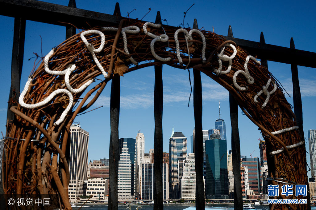 當地時間2017年9月8日，美國紐約，9/11國家紀念博物館為&ldquo;9&middot;11&rdquo;事件16周年紀念活動做準備。***_***NEW YORK, NY - SEPTEMBER 8: A commemorative wreath hangs along the Brooklyn Promenade with Lower Manhattan and One World Trade Center in the background, September 8, 2017 in New York City. New York City is preparing to mark the 16th anniversary of the September 11th terrorist attacks that struck New York City and Washington, DC in 2001. (Photo by Drew Angerer/Getty Images)