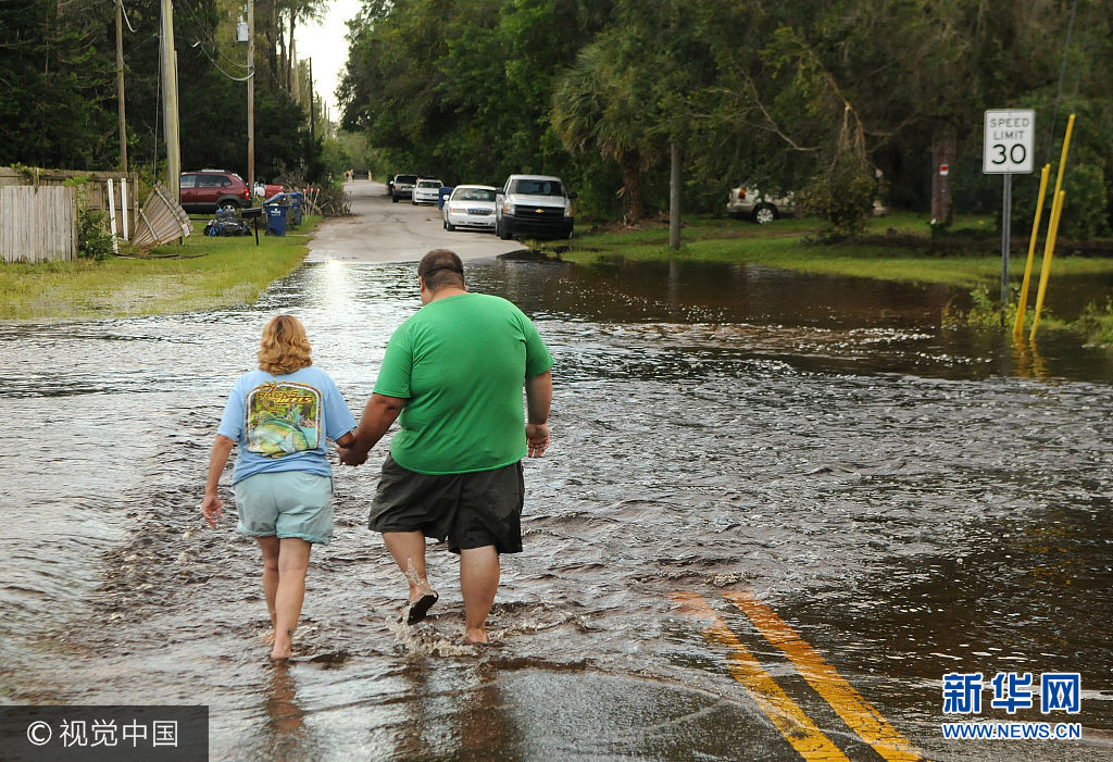 當地時間2017年9月13日，美國佛州，颶風&ldquo;艾爾瑪&rdquo;給當地造成極大破壞。因颶風&ldquo;艾爾瑪&rdquo;被疏散的佛羅裏達州民眾開始返回家園，許多人卻發現自己的房屋被風暴摧毀，數百萬人遭遇巨大財産損失，面臨著漫長的家園重建之路。當地時間14日，美國總統特朗普和第一夫人梅拉尼婭將前往佛州視察災情。***_***September 13, 2017- Elfers, Florida, United States - Debbie Jared (left) and her son, Ryan Jared hold each other's hands while walking to their home in a road which flooded with water from the Anclote River in Elfers, Florida on September 13, 2017. The river rose to four feet above flood stage in the aftermath of Hurricane Irma. (Paul Hennessy/Polaris)