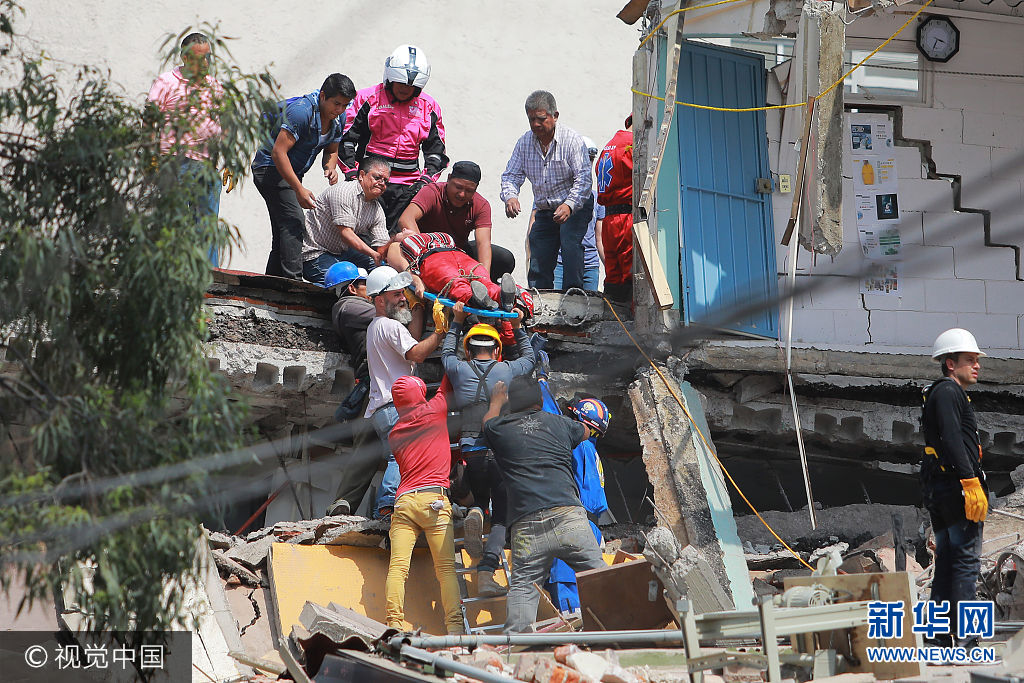 当地时间2017年9月19日，墨西哥墨西哥城，墨西哥发生7.1级地震，震源深度50千米。墨西哥莫雷洛斯州州长19日在其个人推特账户上说，当天的地震已造成该州至少42人死亡。***_***MEXICO CITY, MEXICO - SEPTEMBER 19: Rescuers and residents carry a woman on stretcher amid the ruins of a building knocked down by a magnitude 7.1 earthquake that jolted central Mexico damaging buildings, knocking out power and causing alarm throughout the capital on September 19, 2017 in Mexico City, Mexico. The earthquake comes 32 years after a magnitude-8.0 earthquake hit on September 19, 1985. (Photo by Hector Vivas/Getty Images)