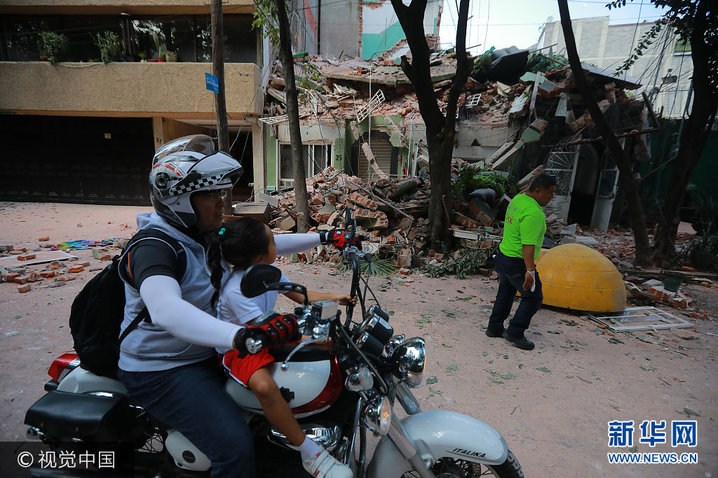 当地时间2017年9月19日，墨西哥墨西哥城，墨西哥发生7.1级地震，震源深度50千米。墨西哥莫雷洛斯州州长19日在其个人推特账户上说，当天的地震已造成该州至少42人死亡。***_***MEXICO CITY, MEXICO - SEPTEMBER 19: A girls looks to a destroyed building knocked down by a magnitude 7.1 earthquake that jolted central Mexico damaging buildings, knocking out power and causing alarm throughout the capital on September 19, 2017 in Mexico City, Mexico. The earthquake comes 32 years after a magnitude-8.0 earthquake hit on September 19, 1985. (Photo by Hector Vivas/Getty Images)