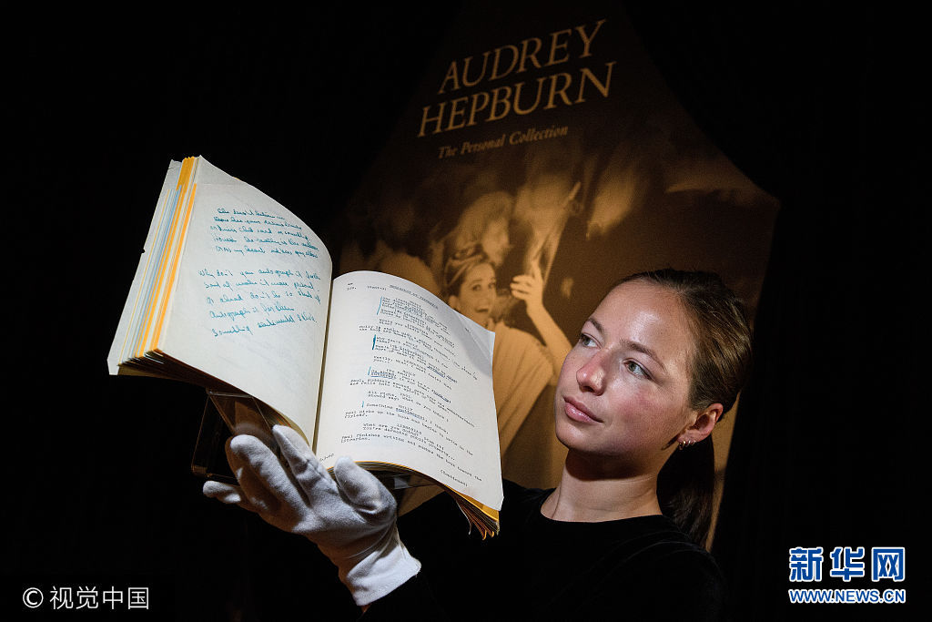 ***_***LONDON, ENGLAND - SEPTEMBER 22:  A gallery assistant poses with the working script for the film 'Breakfast at Tiffanys' (reserve price &pound;60,000-90,000) during a preview of items from the sale of actrees Audrey Hepburn's personal collection at Christies on September 22, 2017 in London, England.  The sale sees over 500 lots from the actresses career and personal life being sold at auction.  (Photo by Leon Neal/Getty Images)