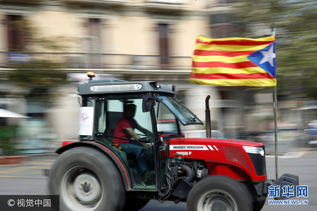 当地时间2017年9月29日，西班牙巴塞罗那，农民开拖拉机游行支持加泰罗尼亚地区独立公投。***_***A farmer carries a Catalan separatist flag on his tractor during a protest to show support for the banned referendum on independence from Spain in Barcelona, Spain September 29, 2017. Juan Medina