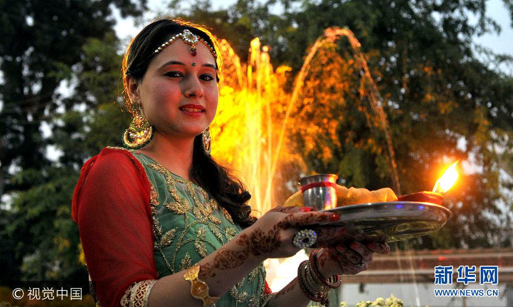 当地时间2017年10月8日，印度古尔冈，当地庆祝&ldquo;女人节&rdquo;，已婚妇女盛装打扮为丈夫祈祷。&ldquo;女人节&rdquo;是印度教传统节日，节日期间，妇女要进行斋戒并为家人祈祷，她们身着节日艳服，在寺庙内唱歌，进行&ldquo;女人节&rdquo;祷告。***_***JAMMU, INDIA - OCTOBER 8: Hindu married women perform rituals during Karva Chauth festival, on October 8, 2017 in Jammu, India. Karva Chauth is a one-day festival celebrated by Hindu women in Northern India, in which married women fast from sunrise to moonrise for the safety and longevity of their husbands. (Photo by Nitin Kanotra/Hindustan Times via Getty Images)
