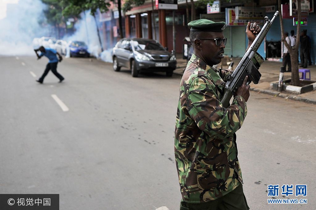 当地时间2017年10月13日，肯尼亚内罗毕，反对党国家超级联盟的支持者上街游行,抗议独立选举和边界委员会。***_***A police officer re-loads his rifle as he prepares to fire in the air to attempt to disperse groups of demonstrators on October 13, 2017, in Nairobi, as supporters of theopposition coalition National Super Alliance (NASA) took to the streets for the third day in a week. Hundreds of opposition supporters took to the streets of Kenya's main cities on October 13 in defiance of a government ban on protests as the country is gripped by uncertainty over its presidential election TONY KARUMBA
