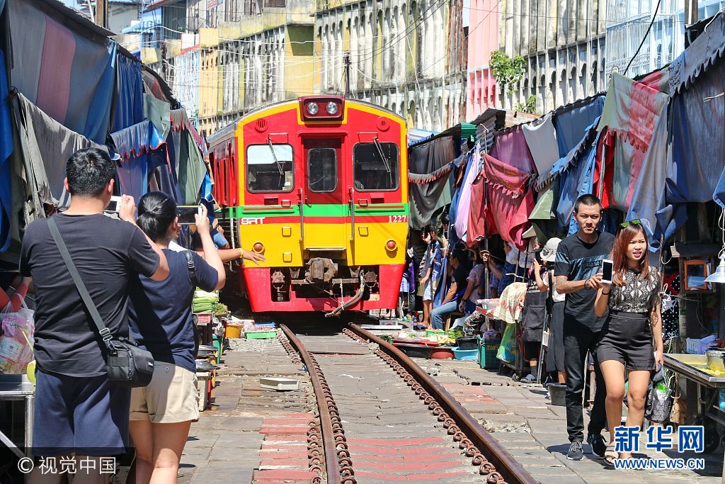 ***_***当地时间2017年9月9日，泰国夜功府，美功菜摊贩们和游客在等待列车到来。