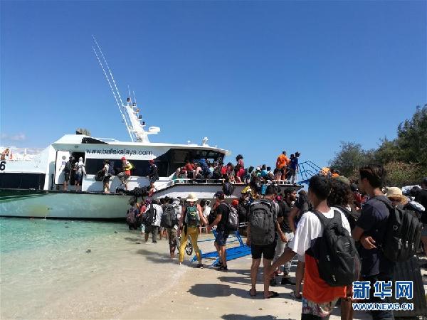 8月6日，游客在印度尼西亚龙目岛附近的特拉旺安岛海滩上等待登船撤离。 新华社发（梁芳芳摄）