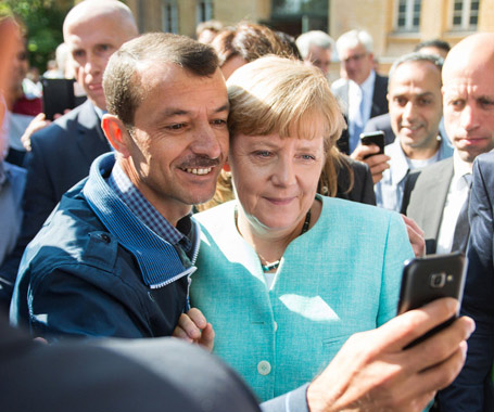 默克尔慰问抵德难民玩自拍秀亲民