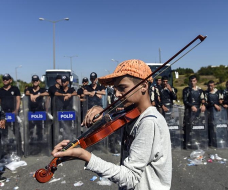 13岁小难民在警察盾牌阵前拉小提琴