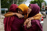 三名女子抱在一起做祷告