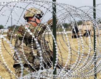 美国士兵铺设铁丝网应对移民压境