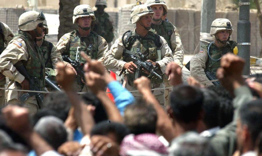 2003年6月，美軍士兵持槍面對示威的前伊拉克軍人。