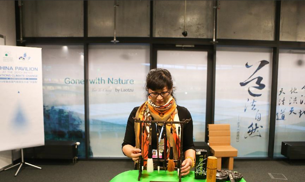 11月13日，在波兰华沙，一名工作人员在“中国角”会场摆放文房四宝。