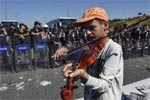小难民:13岁男孩在警察盾牌阵前拉小提琴